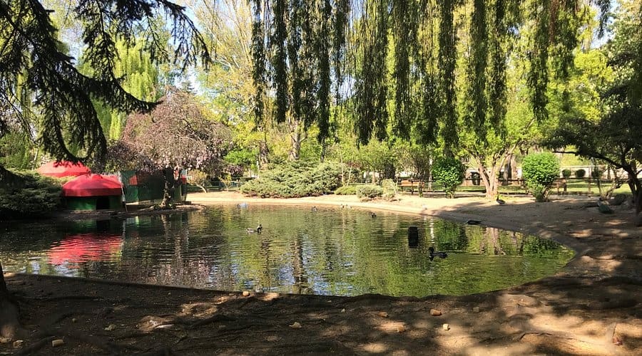 Zona verde del Parque de Quevedo con juegos infantiles y aviario, perfecto para planes con niños en León.